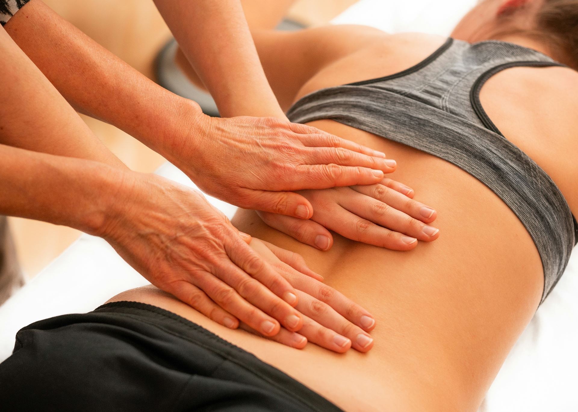 A physiotherapist placing their hand on someones back